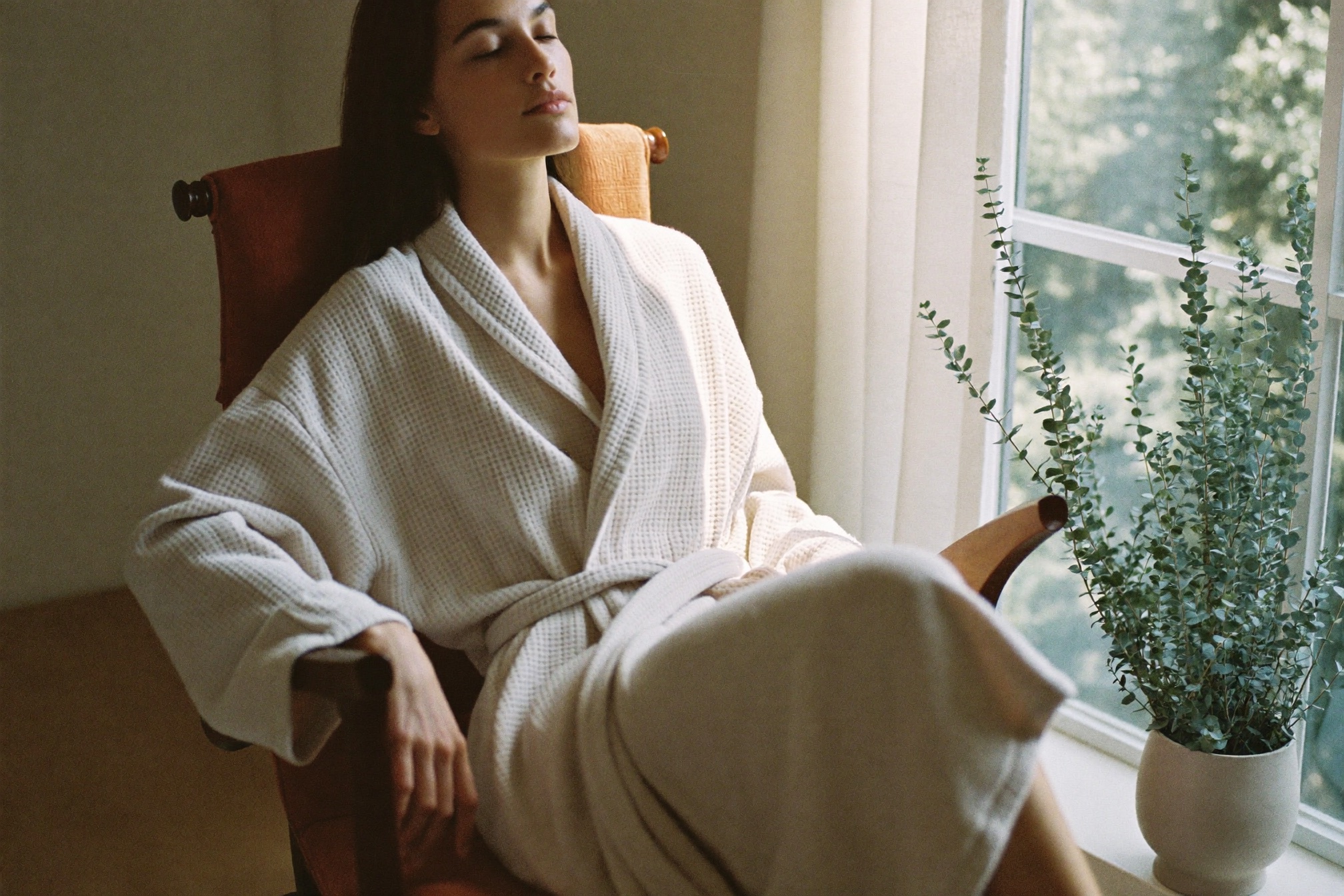 A person wrapped in a plush oatmeal waffle robe by a sunlit window